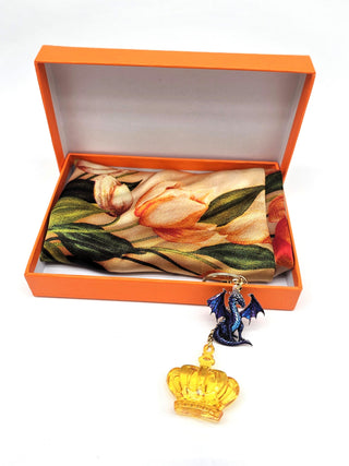 A fantasy-themed keychain with a purple dragon charm and a translucent golden crown, highlighted against a clean white backdrop.