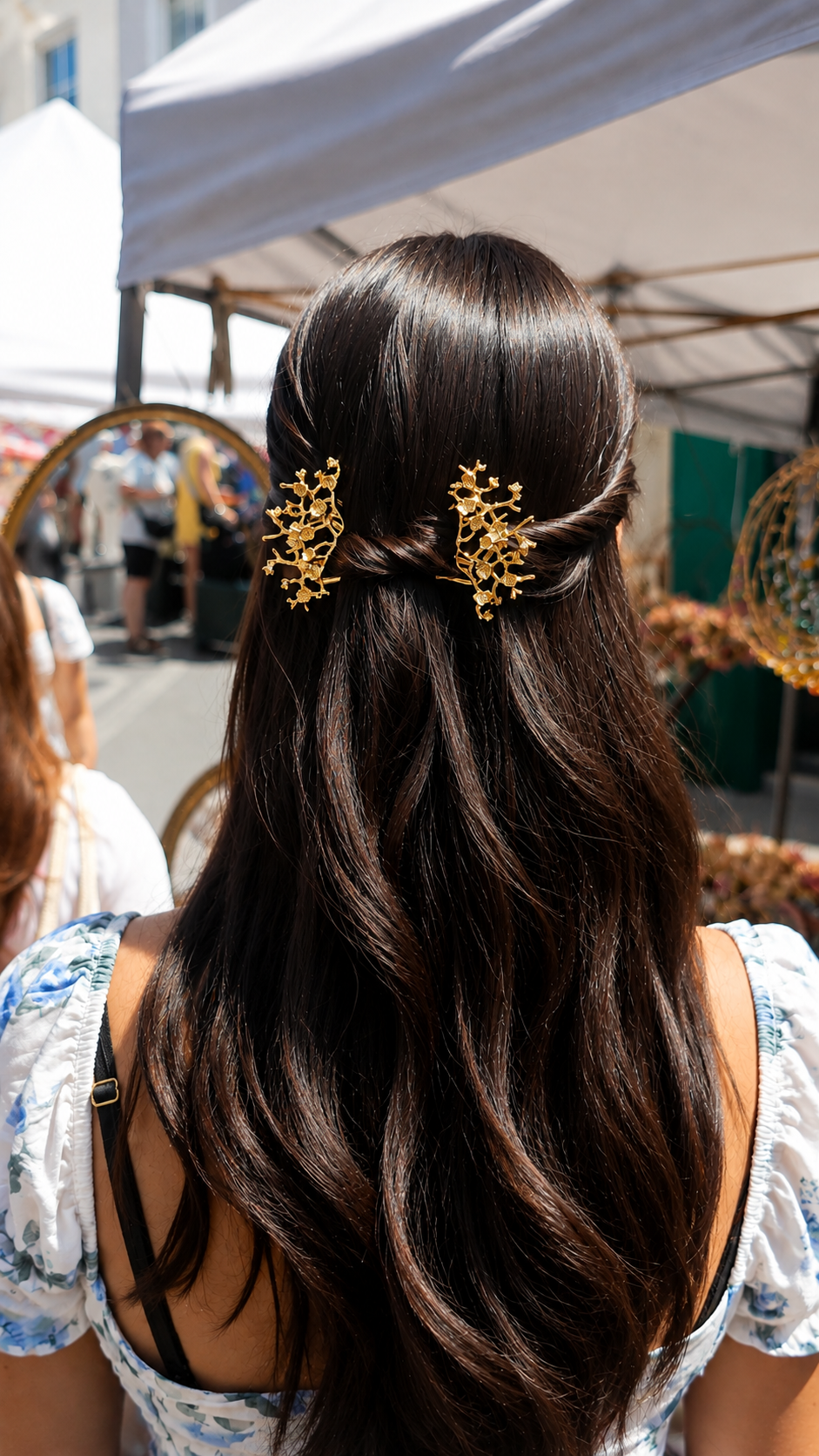 Gold floral hair combs styled in a half-up hairstyle on long dark hair