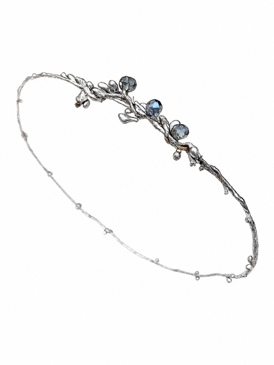 Silver headband with blue stones on a white background