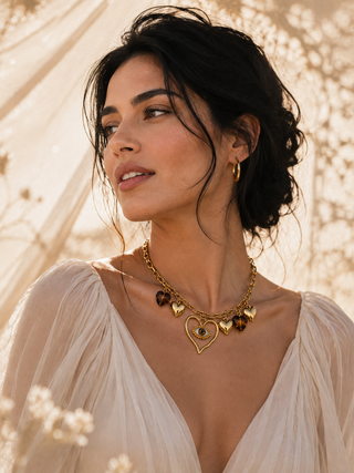 Gold evil eye heart necklace styled on woman with black hair