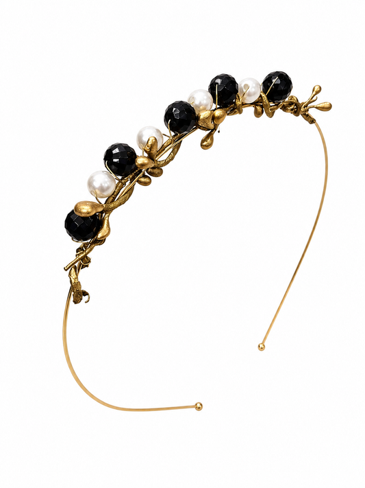 Gold headband with black and white beads on a white background
